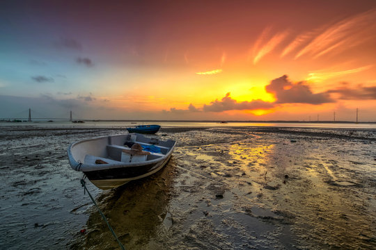 Long exposure picture of fishing boat with golden sunset as a background