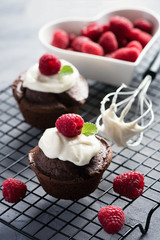 Chocolate muffins or cupcakes with raspberries, healthy breakfast, homemade snack, selective focus, toned image.