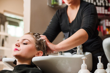 Obraz na płótnie Canvas Hairdresser and woman during hair wash