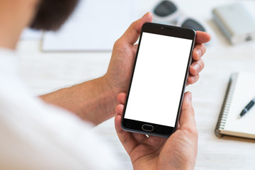 The man uses a smartphone with a white screen for the mock up. Concepts of using mobile devices,...
