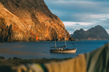 View on a white sailing boat anchored in natural harbour in a secret bay close to Desertas islands...