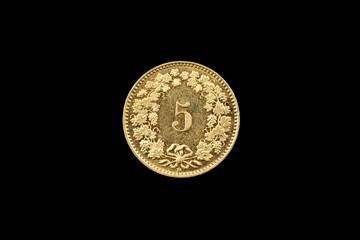A macro image of a Swiss 5 centimes coin isolated on a black background