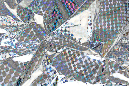 Holographic aluminium foil decor foil closeup pattern texture as background. Macro photo