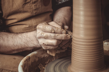 elderly man making pot using pottery wheel in studio