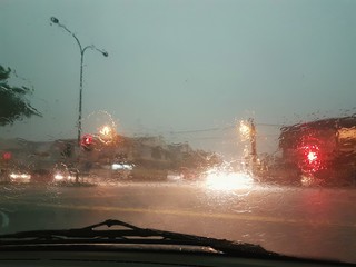 Behind the wheel view during extreme weather conditions of heavy rain, making road view hardly...