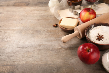 Composition with raw puff pastry and ingredients on wooden background