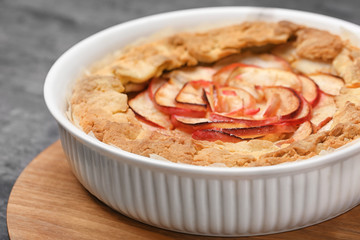 Baking dish with freshly cooked apple tart on table, closeup