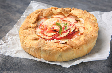 Tasty freshly cooked apple tart on grey background