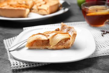 Plate with piece of tasty apple tart on table, closeup