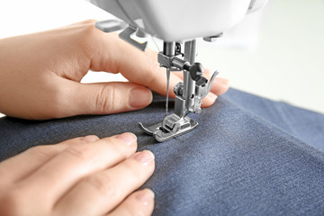 Woman using sewing machine, closeup