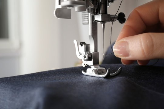 Woman using sewing machine, closeup