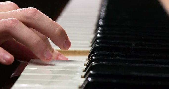 Learning the Elementary Sounds. The child's fingers close-up slowly touch the piano keys, extracting a simple melody. . Filmed at a speed of 120fps