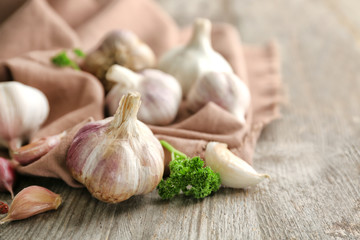 Fresh garlic with napkin on wooden table