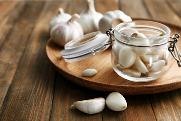 Fototapeta na wymiar Jar with garlic cloves on plate