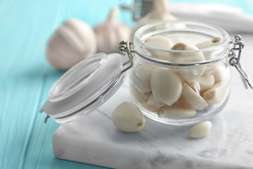 Jar with garlic cloves on board