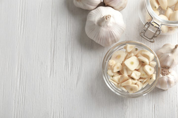 Bowl with chopped garlic on wooden table