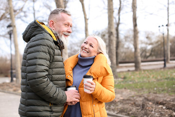 Happy mature couple with coffee outdoors