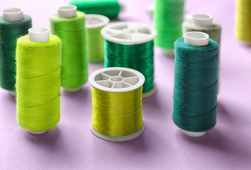 Set of sewing threads on color background