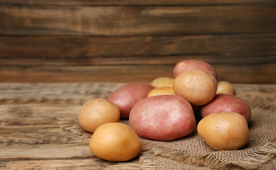 Fresh raw potatoes on wooden table