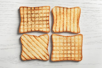 Tasty toasted bread on wooden table