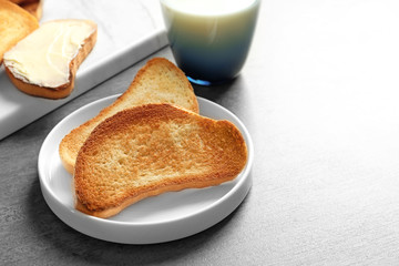 Fototapeta na wymiar Plate with tasty toasted bread on table