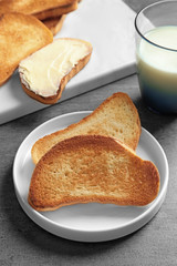 Plate with tasty toasted bread on table