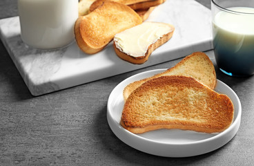 Plate with tasty toasted bread on table