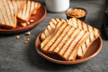 Plate with tasty toasted bread on table