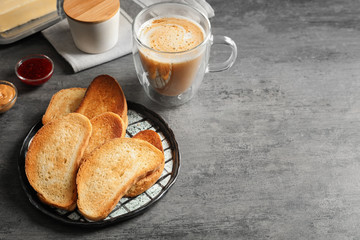 Plate with tasty toasted bread on table
