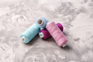 Fototapeta na wymiar Colorful sewing threads on grey background