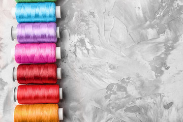 Colorful sewing threads on grey background