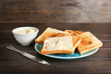 Plate with toasted bread on table