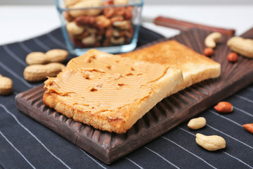 Wooden board with toasted bread on table