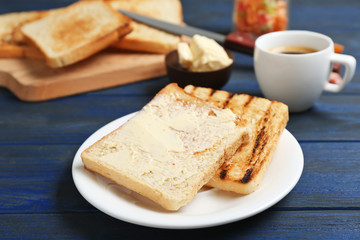 Plate with toasted bread on table