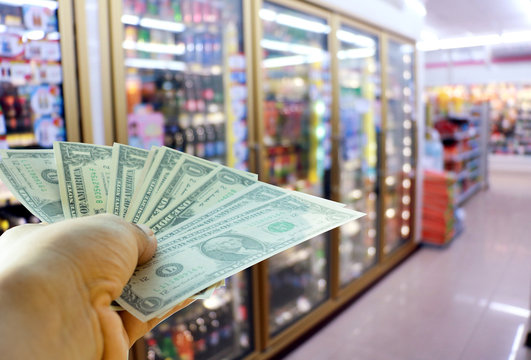 A hand holding dollars in shop. A man holding dollars for cash  in store. Money for sales exchange. Photo concept  finances and money.