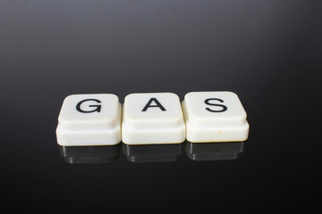 Gas text word title caption label cover backdrop background. Alphabet letter toy blocks on black...