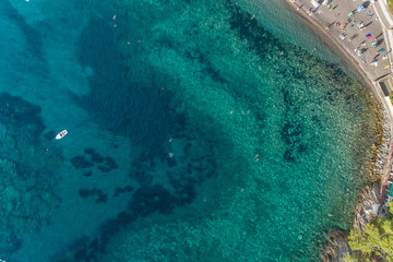 Aerial view of the turquoise sea surface in which people bathe 