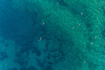 Aerial view of the turquoise sea surface in which people bathe 
