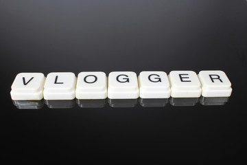 Vlogger text word title caption label cover backdrop background. Alphabet letter toy blocks on...