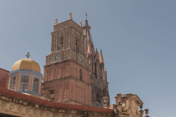 Top portion of the Parroquia de San Miguel Arcángel, church tower with clock, and other architectural details, in San Miguel de Allende, Mexico - 191125892