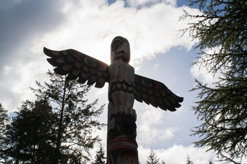 Silhouette of wooden totem pole against a summer sky