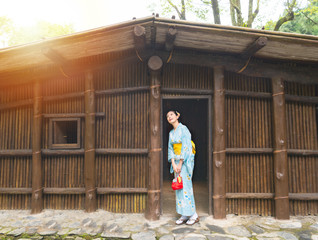 happy woman standing in front of old wooden house