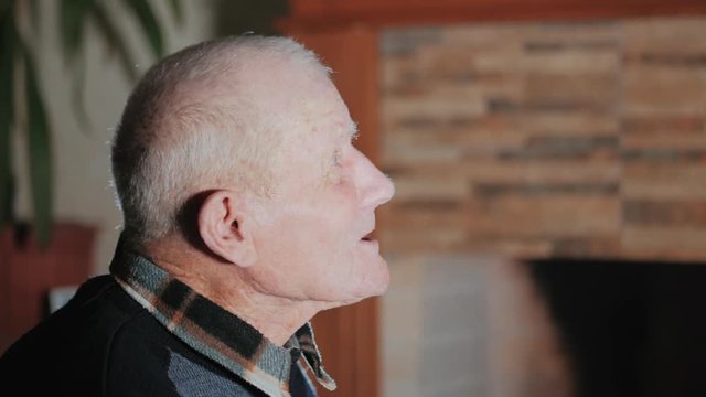 Very old grey haired man talking with somebody at home. 92 years old grandfather portrait. Senior discusses interesting topic with a relative