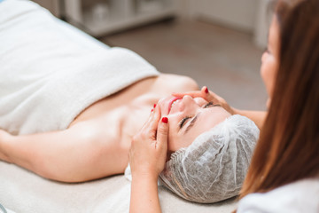 Obraz na płótnie Canvas Beautiful woman having a facial massage beauty treatment