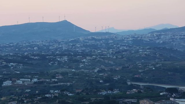 Early morning preceding dawn Castellammare del Golfo and Alcamo towns from resting place Localita Belvedere Castellammare del Golfo (Trapani region, Sicily, Italy). Mountains and wind turbines in far.