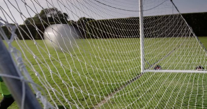 A young goal keeper fails to save a goal during a match in a soccer field. Shot on RED Epic.