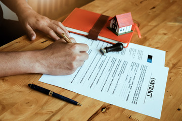 Naklejka premium customer sign contract and pressing rubber stamp on house contract document. Agreement concept.