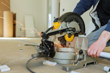 Worker cutting metal with grinder. Sparks while grinding iron