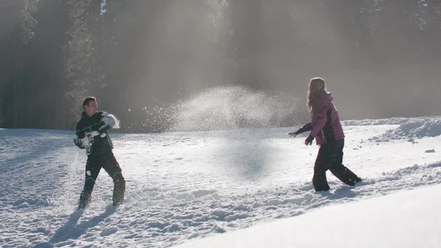 Young couple having a fun snowball fight on a sunny day
