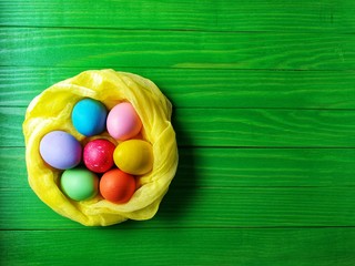multicolored eggs on wooden green background 